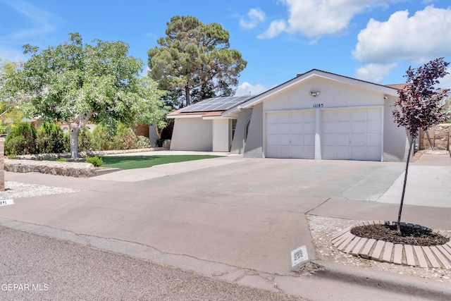 11185 Tenaha Ave, El Paso, TX 79936 - ranch-style house featuring a garage, driveway, and solar panels
