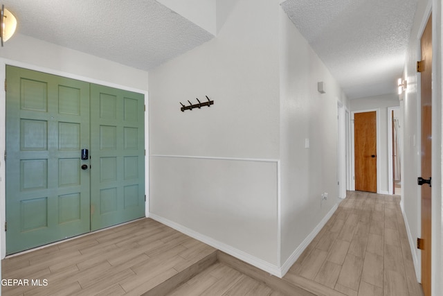 11185 Tenaha Ave, El Paso, TX 79936 - foyer entrance with a textured ceiling, light wood-type flooring, and baseboards
