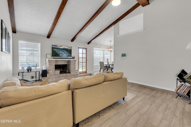 11185 Tenaha Ave, El Paso, TX 79936 - living area featuring baseboards, a textured ceiling, a fireplace, a chandelier, and light wood finished floors