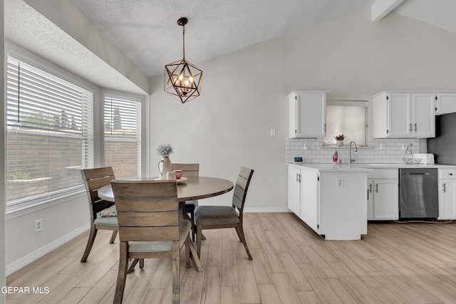 11185 Tenaha Ave, El Paso, TX 79936 - dining room with a chandelier, plenty of natural light, light wood-type flooring, baseboards, and a textured ceiling