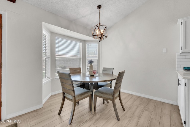 11185 Tenaha Ave, El Paso, TX 79936 - dining area featuring healthy amount of natural light, a textured ceiling, a chandelier, and light wood-style flooring