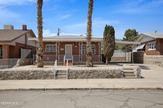 4013 Hueco Ave, El Paso, TX 79903 - view of front of property with a porch, brick siding, and a carport