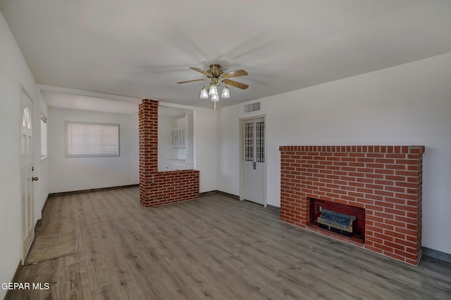 4013 Hueco Ave, El Paso, TX 79903 - unfurnished living room with wood finished floors, a ceiling fan, a fireplace, and baseboards