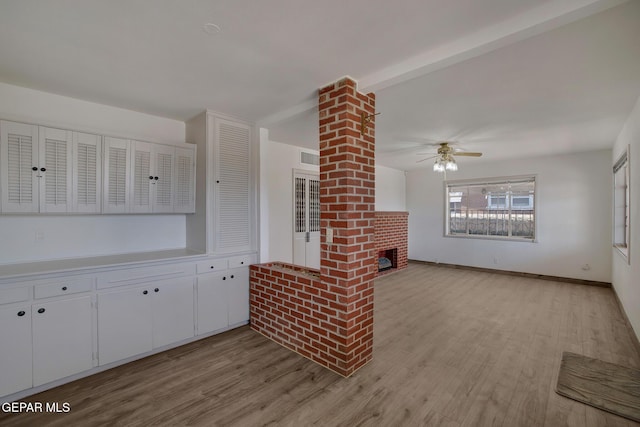 4013 Hueco Ave, El Paso, TX 79903 - unfurnished living room featuring light wood-type flooring, a ceiling fan, a brick fireplace, and baseboards