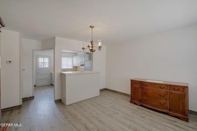 4013 Hueco Ave, El Paso, TX 79903 - kitchen with a chandelier, light wood-style floors, light countertops, hanging light fixtures, and baseboards