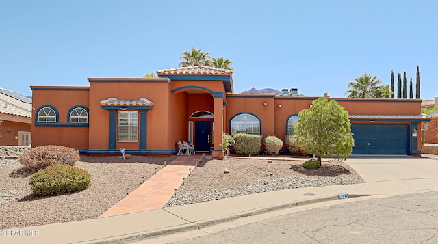 904 Las Palmas Way, El Paso, TX 79912 - mediterranean / spanish-style house featuring an attached garage, concrete driveway, stucco siding, and a tiled roof
