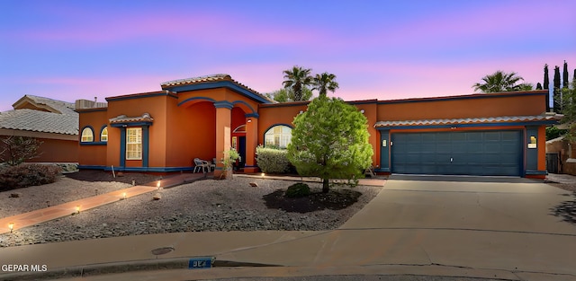 904 Las Palmas Way, El Paso, TX 79912 - mediterranean / spanish home with driveway, a garage, stucco siding, and a tiled roof