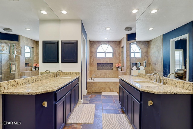 904 Las Palmas Way, El Paso, TX 79912 - full bathroom with stone tile flooring, a bath, two vanities, a tile shower, and recessed lighting