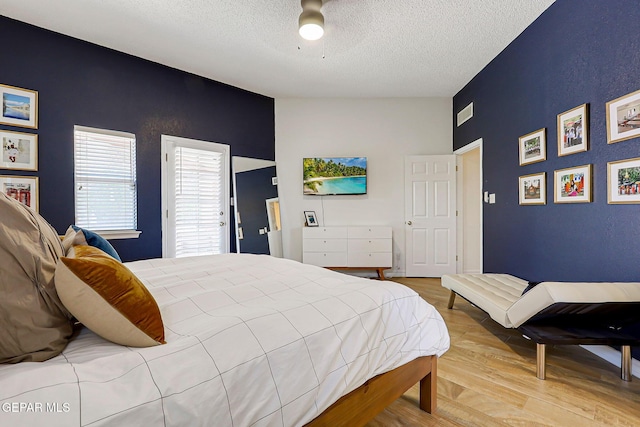904 Las Palmas Way, El Paso, TX 79912 - bedroom featuring an accent wall, a textured ceiling, and wood finished floors