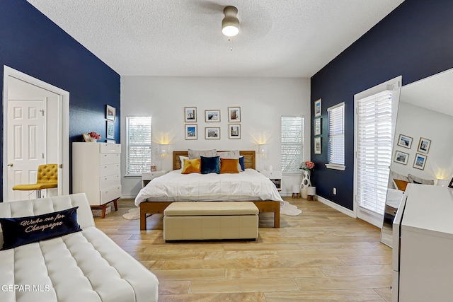 904 Las Palmas Way, El Paso, TX 79912 - bedroom featuring light wood-style floors, a textured ceiling, a ceiling fan, and baseboards