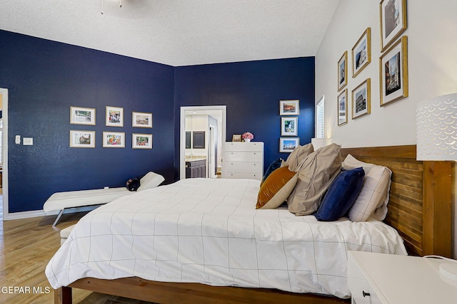 904 Las Palmas Way, El Paso, TX 79912 - bedroom with wood finished floors, a textured ceiling, and ensuite bath