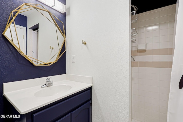 904 Las Palmas Way, El Paso, TX 79912 - bathroom featuring a textured wall, vanity, and a tile shower