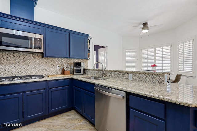 904 Las Palmas Way, El Paso, TX 79912 - kitchen with appliances with stainless steel finishes, a sink, blue cabinets, a peninsula, and a ceiling fan