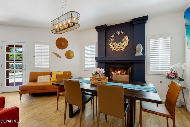 904 Las Palmas Way, El Paso, TX 79912 - dining room with light wood finished floors, a fireplace, and a chandelier