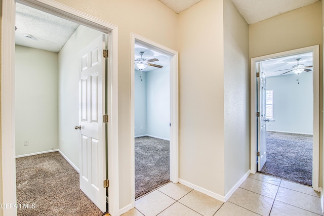 11361 Charles Reynolds Ln, El Paso, TX 79934 - hall with light colored carpet, baseboards, light tile patterned floors, and a textured ceiling