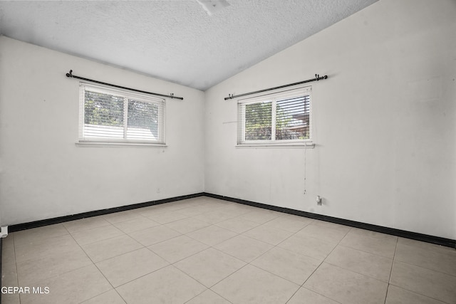 9913 Bomarc St, El Paso, TX 79924 - empty room with plenty of natural light, a textured ceiling, vaulted ceiling, and baseboards