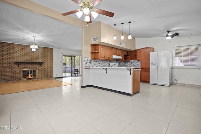 9913 Bomarc St, El Paso, TX 79924 - kitchen with white refrigerator with ice dispenser, open shelves, ceiling fan, a peninsula, and a kitchen bar