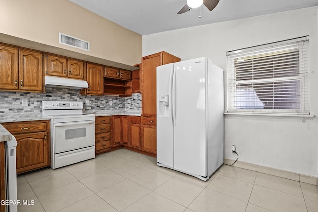 9913 Bomarc St, El Paso, TX 79924 - kitchen featuring white appliances, under cabinet range hood, brown cabinetry, a ceiling fan, and backsplash