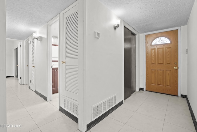 9913 Bomarc St, El Paso, TX 79924 - entrance foyer featuring a textured ceiling, baseboards, and light tile patterned floors