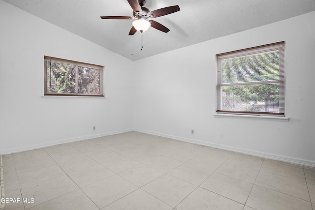 9913 Bomarc St, El Paso, TX 79924 - empty room with a ceiling fan, vaulted ceiling, baseboards, light tile patterned flooring, and a textured ceiling