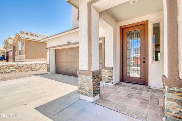 12772 Silver Streak Ave, El Paso, TX 79928 - entrance to property featuring stucco siding, driveway, stone siding, and an attached garage