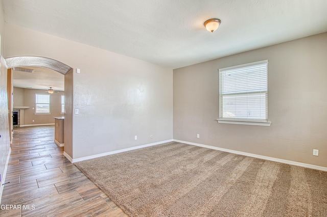 12772 Silver Streak Ave, El Paso, TX 79928 - spare room with baseboards, a ceiling fan, arched walkways, and wood finished floors