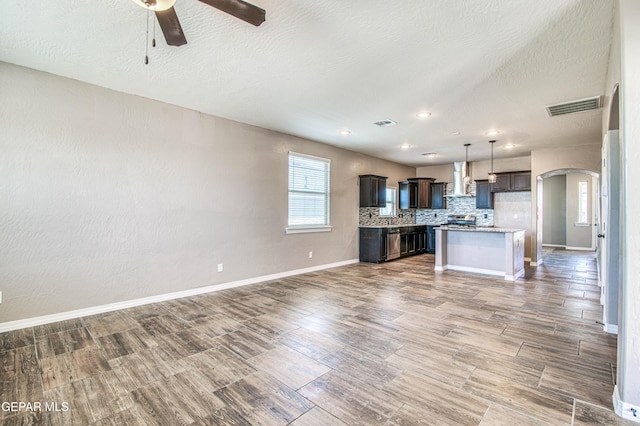 12772 Silver Streak Ave, El Paso, TX 79928 - unfurnished living room featuring a ceiling fan, wood finished floors, baseboards, arched walkways, and recessed lighting