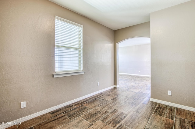 12772 Silver Streak Ave, El Paso, TX 79928 - empty room with arched walkways, wood finished floors, and baseboards