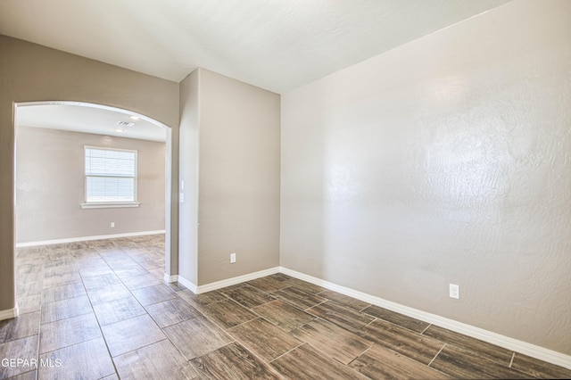 12772 Silver Streak Ave, El Paso, TX 79928 - unfurnished room with arched walkways, wood finish floors, and baseboards