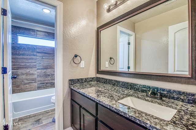 12772 Silver Streak Ave, El Paso, TX 79928 - bathroom with a textured wall, vanity, toilet, wood finished floors, and shower / tub combination