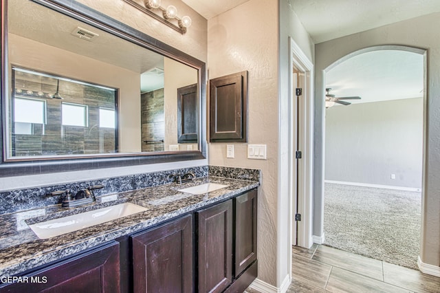 12772 Silver Streak Ave, El Paso, TX 79928 - bathroom with double vanity, a ceiling fan, a textured wall, baseboards, and wood tiled floors