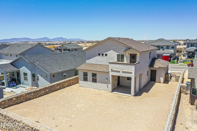 12772 Silver Streak Ave, El Paso, TX 79928 - rear view of house featuring stucco siding, a residential view, a mountain view, a shingled roof, and a patio area