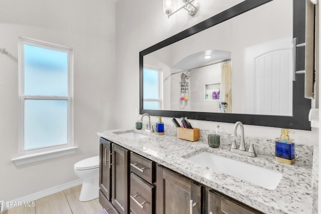 2367 Enchanted Peaks Ln, El Paso, TX 79911 - bathroom with double vanity, toilet, baseboards, and curtained shower