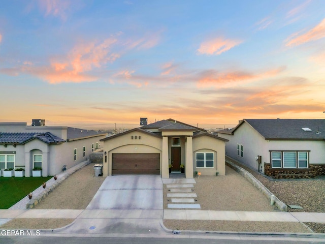 2367 Enchanted Peaks Ln, El Paso, TX 79911 - view of front facade with stucco siding, a garage, and driveway