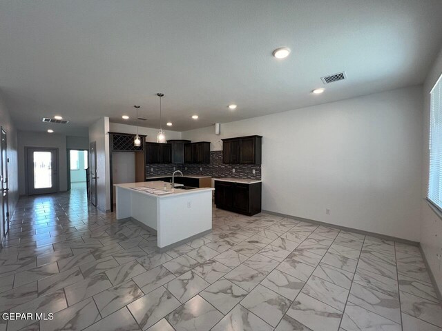 12868 Star Gaze Ave, El Paso, TX 79928 - kitchen with a sink, tasteful backsplash, light countertops, a center island with sink, and recessed lighting