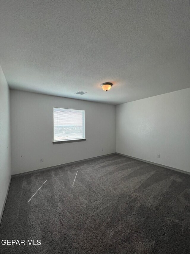 12868 Star Gaze Ave, El Paso, TX 79928 - spare room with dark carpet, a textured ceiling, and baseboards