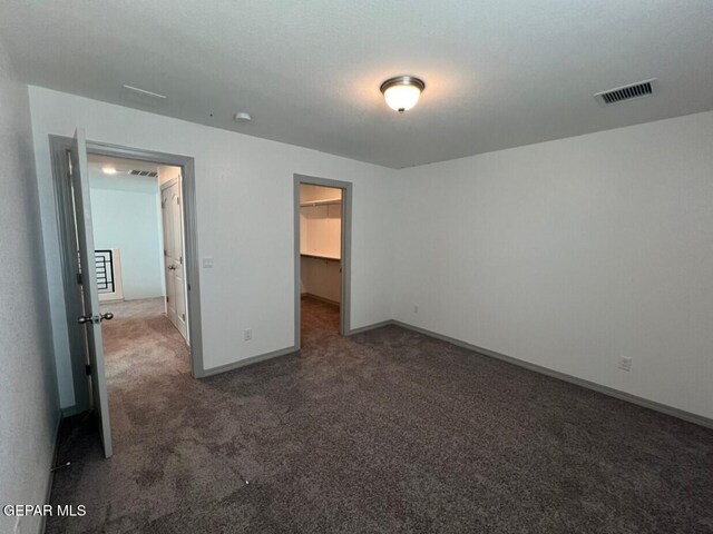 12868 Star Gaze Ave, El Paso, TX 79928 - unfurnished bedroom with carpet floors, baseboards, and a walk in closet