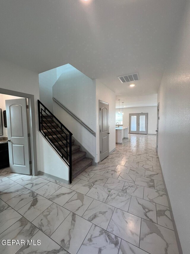 12868 Star Gaze Ave, El Paso, TX 79928 - corridor with light marble finish flooring, stairs, baseboards, and french doors