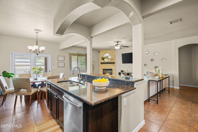 14382 Karen Point Ct, El Paso, TX 79938 - kitchen with stainless steel dishwasher, a sink, light tile patterned floors, a ceiling fan, and a fireplace