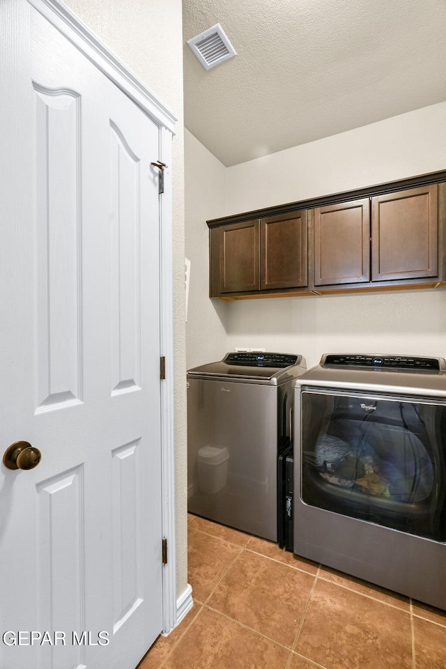 14382 Karen Point Ct, El Paso, TX 79938 - laundry area with washing machine and clothes dryer, cabinet space, a textured ceiling, and light tile patterned floors