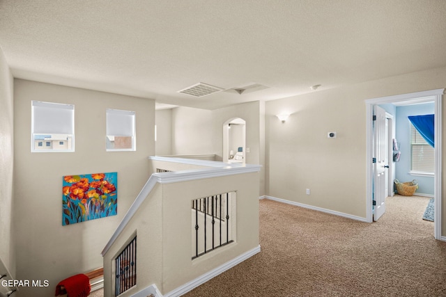 14382 Karen Point Ct, El Paso, TX 79938 - hall featuring carpet, baseboards, a textured ceiling, an upstairs landing, and arched walkways