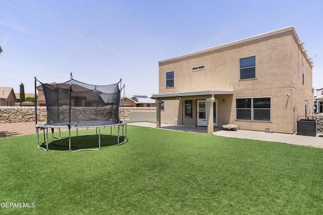 1497 Dunlin Pl, El Paso, TX 79928 - back of house with a trampoline, a patio area, and stucco siding