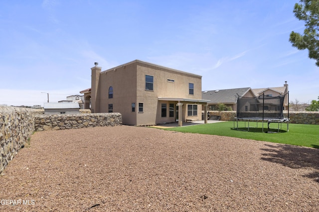 1497 Dunlin Pl, El Paso, TX 79928 - back of property with a trampoline, a patio, stucco siding, and a fenced backyard