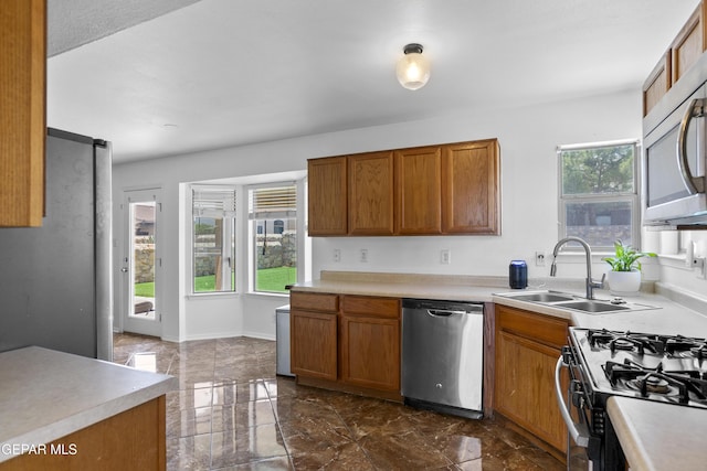 1497 Dunlin Pl, El Paso, TX 79928 - kitchen with appliances with stainless steel finishes, healthy amount of natural light, dark marble finish floors, and brown cabinets