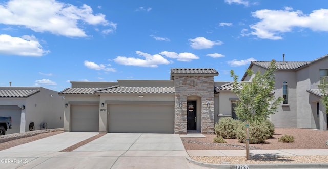 13727 Harbottle St, El Paso, TX 79928 - mediterranean / spanish house with a tile roof, stucco siding, a garage, concrete driveway, and stone siding