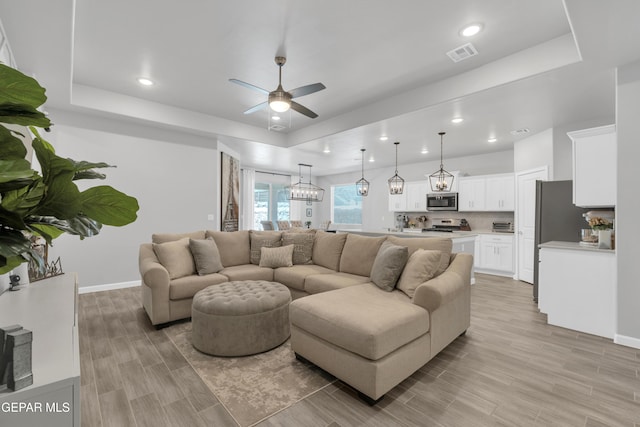 13727 Harbottle St, El Paso, TX 79928 - living room featuring a raised ceiling, light wood-style flooring, a ceiling fan, baseboards, and recessed lighting