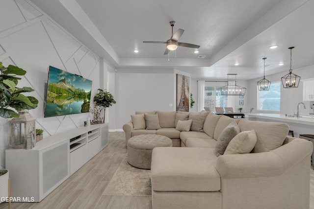 13727 Harbottle St, El Paso, TX 79928 - living area featuring light wood finished floors, ceiling fan, recessed lighting, a tray ceiling, and a chandelier