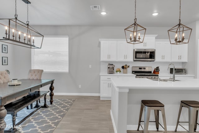 13727 Harbottle St, El Paso, TX 79928 - kitchen with stainless steel appliances, a chandelier, a breakfast bar area, light countertops, and recessed lighting
