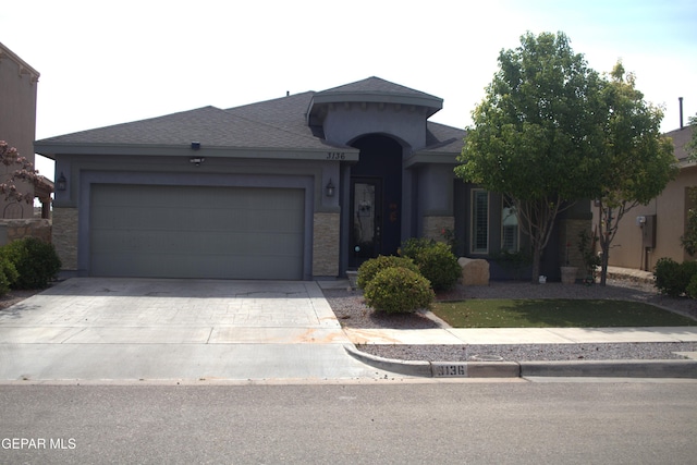 3136 Red Crk, El Paso, TX 79938 - view of front of property with driveway, an attached garage, a shingled roof, stucco siding, and stone siding