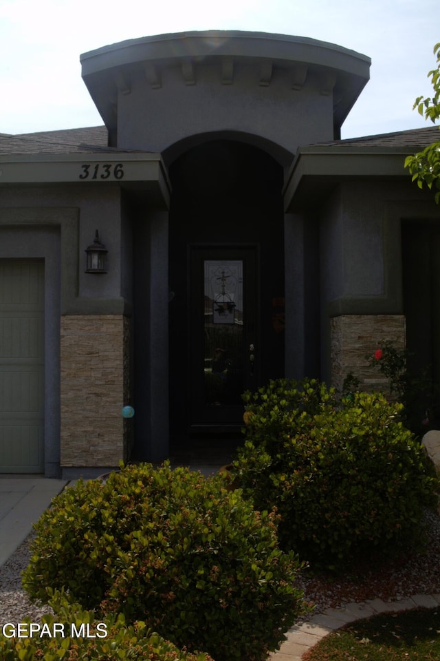 3136 Red Crk, El Paso, TX 79938 - view of exterior entry featuring stone siding, stucco siding, and a garage